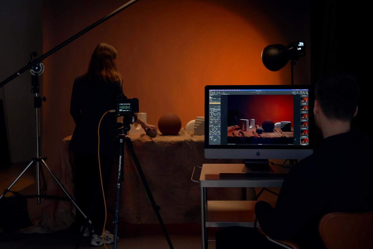 A staged photoshoot with wired camera taking and tethering pictures to the computer.