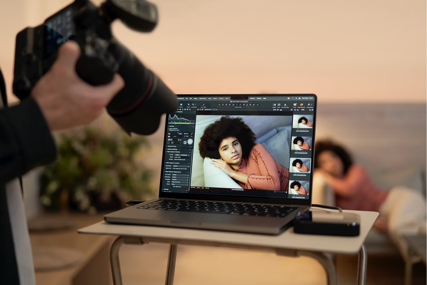カメラで撮影したノートパソコンにワイヤレスで繋がっている女性の写真。